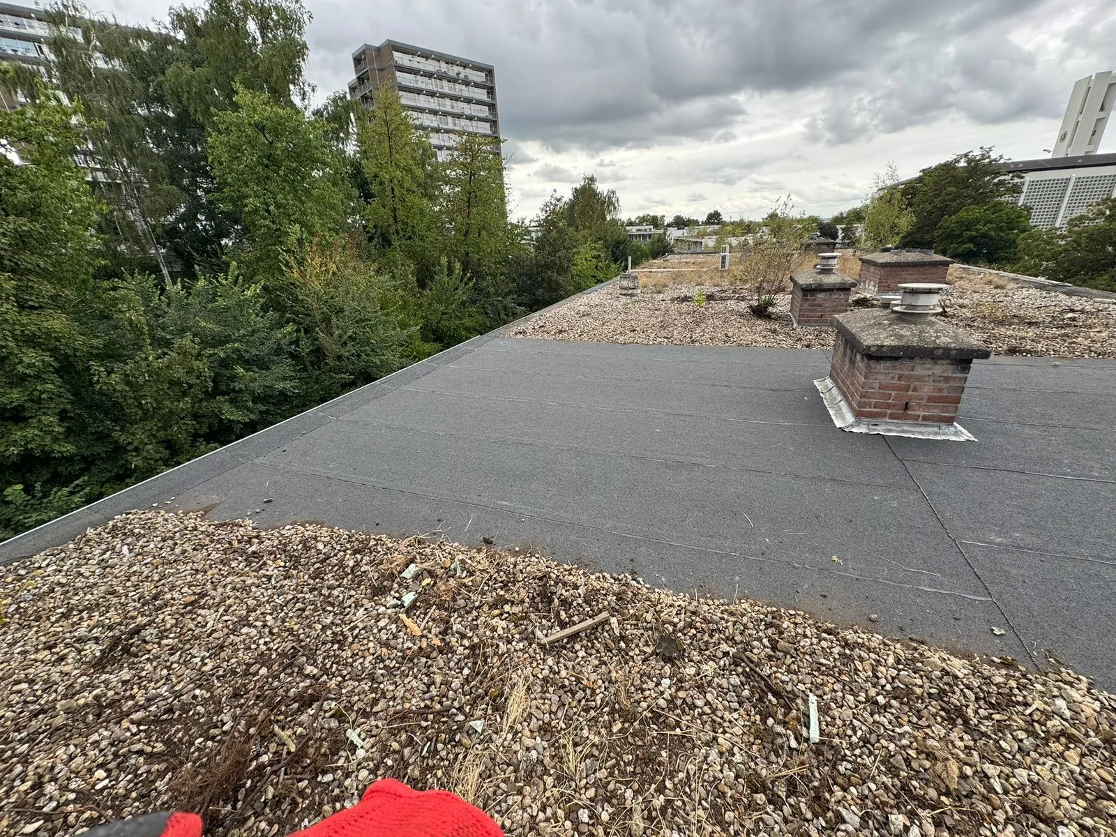 Plat dak met nieuwe bitumen dakbedekking en een schoorsteen